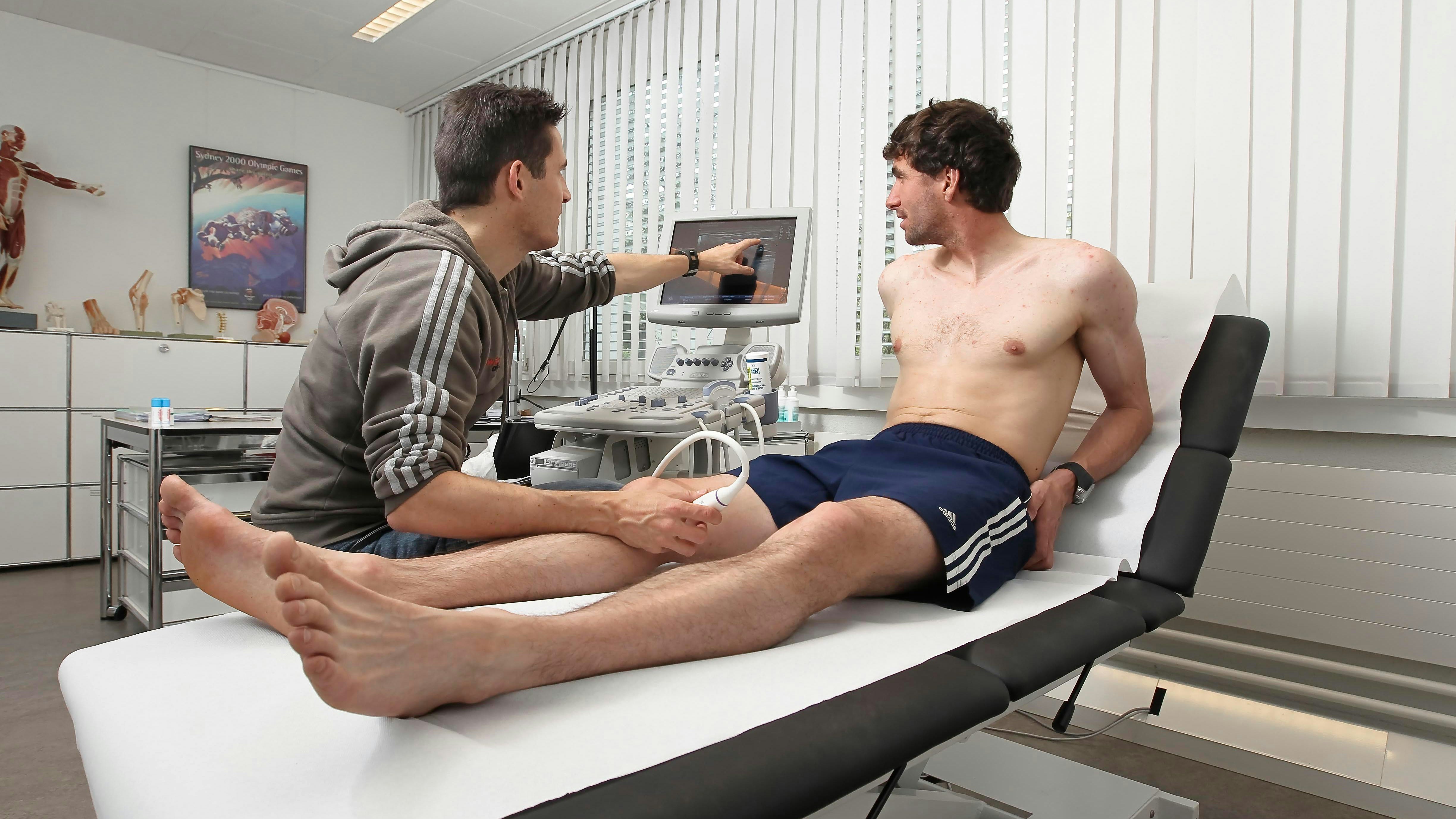 Dr. Patrik Noak untersucht das Knie von Langläufer Curdin Perl mit Ultraschall.
Foto: BASPO / Ueli Känzig