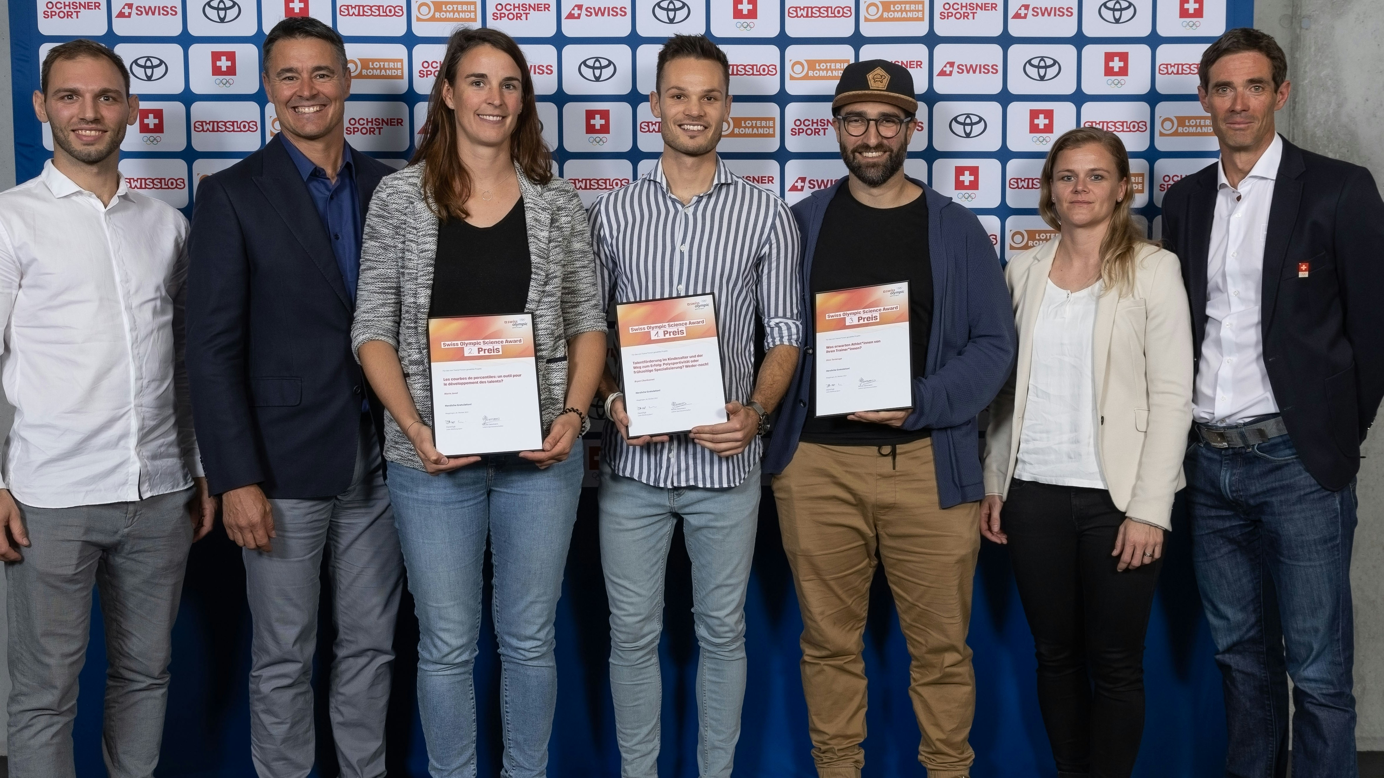 Die Sieger/innen des Swiss Olympic Science Award 2022 umrahmt von Vertretern der Ausrichterorganisationen. (von links) Joris Kuger (Swiss Olympic, Mark Wolf (Trainerbildung Schweiz), Marie Javet (2. Platz), Bryan Charbonnet (1. Rang), Dino Tartaruga (3. Rang), Nicole Gassmann (Swiss Olympic) und David Egli (Swiss Olympic).Foto: BASPO / Ueli Känzig