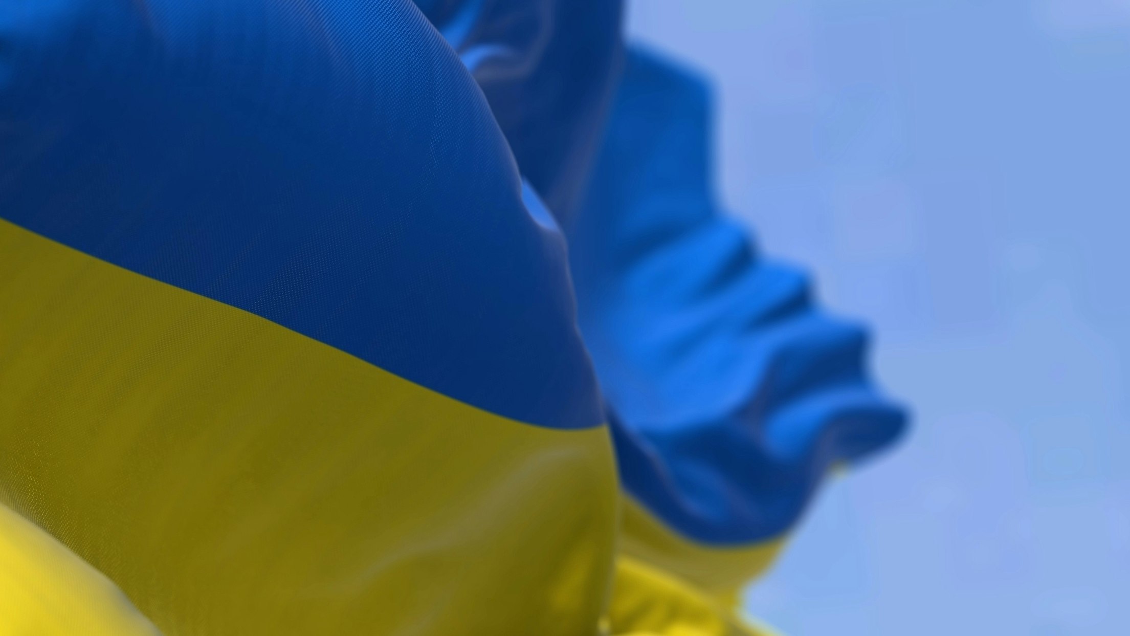 Detail of the national flag of Ukraine waving in the wind on a clear day. Democracy and politics. Eastern Europe country. Patriotism. Selective focus.
